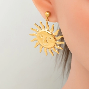Close-up of a model wearing vintage 18K gold-plated irregular sun face drop earrings