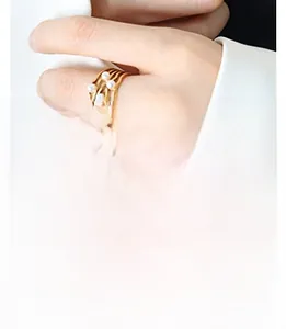 Close-up of wavy gold multi-layer ring with elegant white pearls on hand model