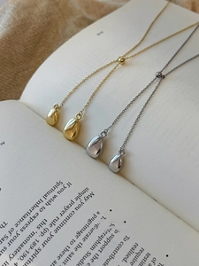Detail showing gold and silver Y-shaped tassel necklaces with teardrop metal pendants