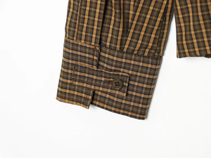 Detailed close-up of yellow and blue plaid shirt cuff with reinforced stitching