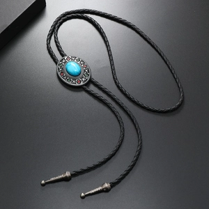 Macro shot of silver bolo tie with turquoise stone and intricate enamel patterns