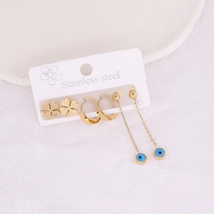 Macro view of gold stainless steel earring set with clover and evil eye charms