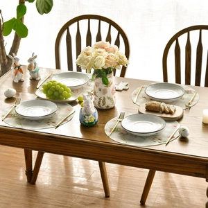 Round linen placemat set with vintage floral print on a rustic wooden dining table