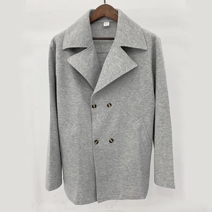 Detailed close-up of a men's grey double-breasted knit jacket with a size M neck label