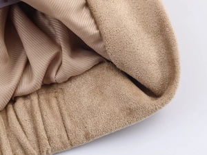 Detailed macro view of khaki suede fabric with smooth satin lining and pleated edge finish