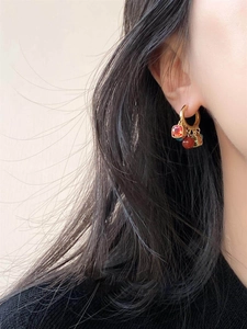 Close-up of retro style zircon and agate beaded earrings worn on a model ear