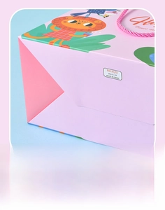 Detail of reinforced bottom and pink woven handle on a cartoon lion paper gift bag