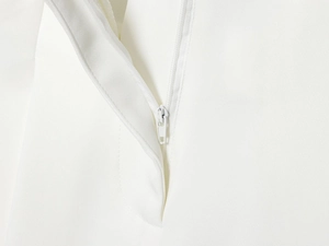 Gros plan sur la fermeture éclair et les coutures précises du pantalon blanc décontracté