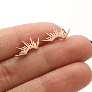 Macro shot of rose gold fan-shaped stud earrings on a finger showing realistic size