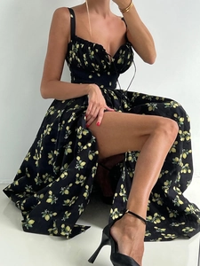 Close-up of floral strap dress featuring high slit and lemon print on black fabric