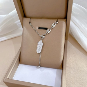 Macro shot of a silver titanium steel pendant necklace with Chinese script in a gift box