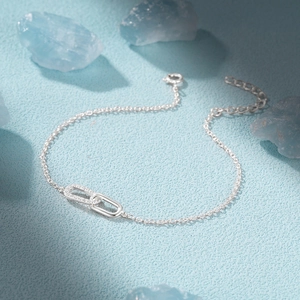 Detail of S925 sterling silver interlocking double loop bracelet with cubic zirconia accents