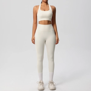 Detail of high-waisted yoga leggings with side pocket and racerback sports bra in cream white