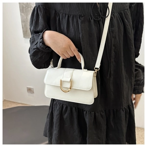 Dettaglio di una borsa bianca vintage in pelle PU con fibbia metallica dorata a forma di U