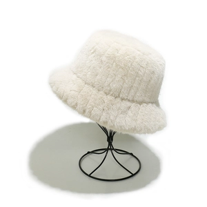 Détail du chapeau bob en fausse fourrure crème montrant la texture douce sur un support
