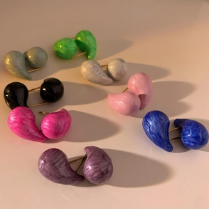 Macro view of water-drop enamel earrings showing diverse colorful marble textures