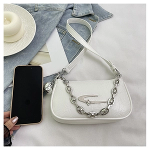Detail of white vintage leather shoulder bag with silver star logo and metal chain