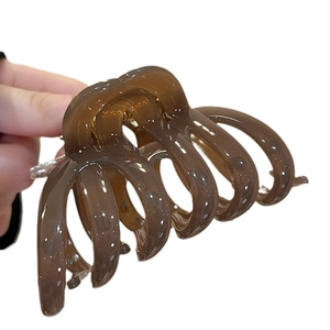 Amber acrylic pumpkin striped claw clip for thick hair shown in a side view