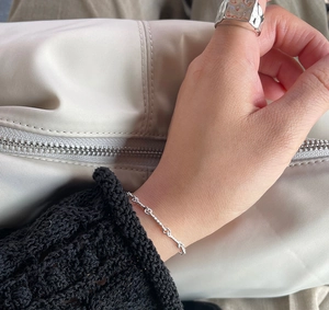 Close-up of minimalist S925 sterling silver twisted chain bracelet on a wrist