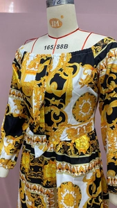Detail view of baroque print featuring gold scrolls and angel patterns on long dress