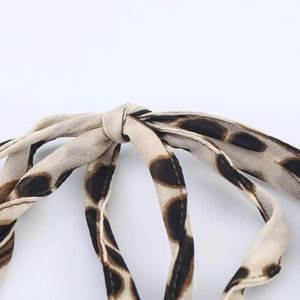 Detailed macro view of leopard print fabric knot detail on a halter neck dress