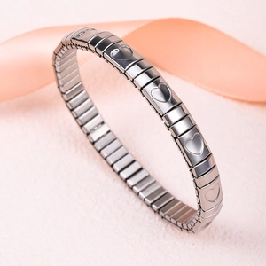 Detailed close-up of a silver stainless steel expansion bracelet with engraved hearts