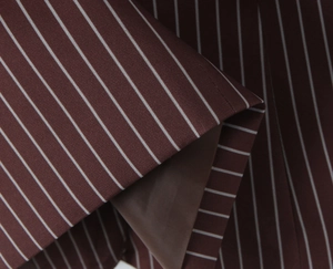 Close-up of brown striped blazer fabric with white pinstripes and matching inner lining