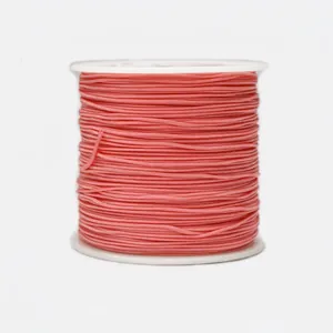 Macro view of 0.8mm coral pink braided cord roll for DIY jewelry making and knotting