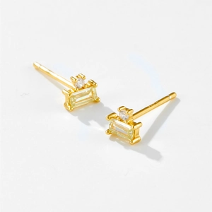 Detail view of rectangular yellow gemstone earrings with gold plating and cubic zirconia