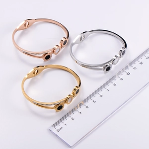 Detailed view of titanium steel bangles featuring Roman numerals and white shell inlays