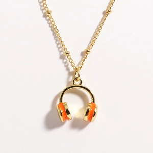 Golden necklace featuring a vibrant orange and gold headphone pendant on a white background