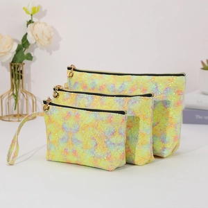 Set of three glittery yellow lace cosmetic bags in various sizes with gold zippers