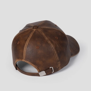 Dettaglio posteriore di un cappellino da baseball in pelle marrone con fibbia in metallo regolabile