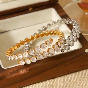 Détail de bracelets spirales luxe or et argent sertis de zircons dans un écrin