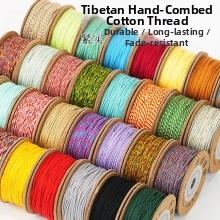 Detailed view of colorful Tibetan style hand-rubbed cotton cords on spools for DIY jewelry