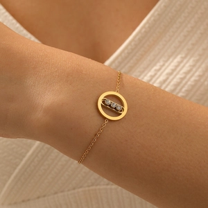 Minimalist gold plated stainless steel bracelet with three sliding diamonds on wrist
