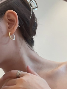 Two-tone textured gold and silver hoop earrings and minimalist ring set on model