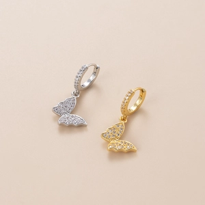 Close-up of gold and silver butterfly earrings with sparkling cubic zirconia inlay