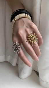 Detail shot of sun-shaped wave texture open rings in gold and silver finish