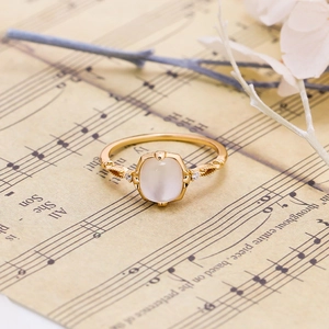 Close-up of a vintage 925 silver gold-plated ring with opal stone and sheet music