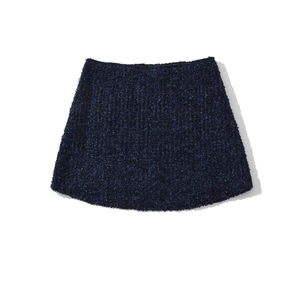 Dettaglio mini gonna in tweed blu scuro con trama a rilievo e taglio a trapezio