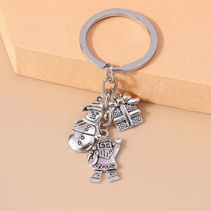 Detail of silver Christmas keychain with snowman, Santa, and gift box charms