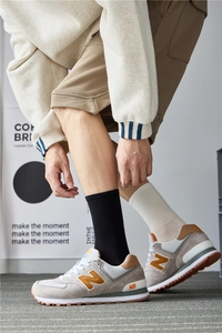 Close-up of suede sneakers with yellow N logo and premium cotton mid-calf socks