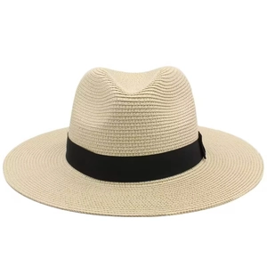 Macro detail of the woven straw texture and black silk ribbon on the Panama beach hat