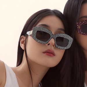 Close-up of luxury cat-eye sunglasses with silver rhinestone frames on a female model