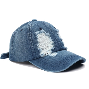 Detailed macro view of heavy distressed denim baseball cap with frayed ripped textures