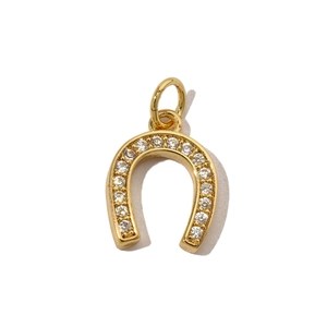 Detailed view of a golden horseshoe pendant with shimmering cubic zirconia micro-inlays