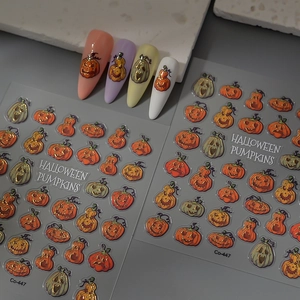 Close-up of Halloween nail stickers with embossed pumpkin and ghost motifs on false nails