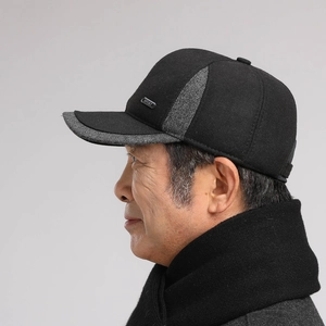 Detail view of winter baseball cap for men featuring grey tweed brim and metal sport badge