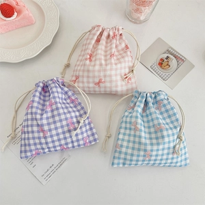 Three-piece checkered drawstring pouches in pink, purple, and blue with bow patterns